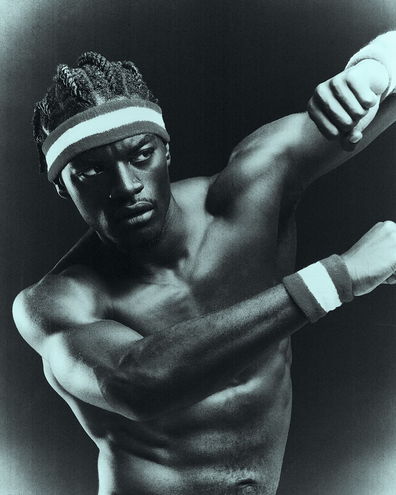 Ibrahim stretching, arms crossed in front of him, cool-toned analog studio portrait