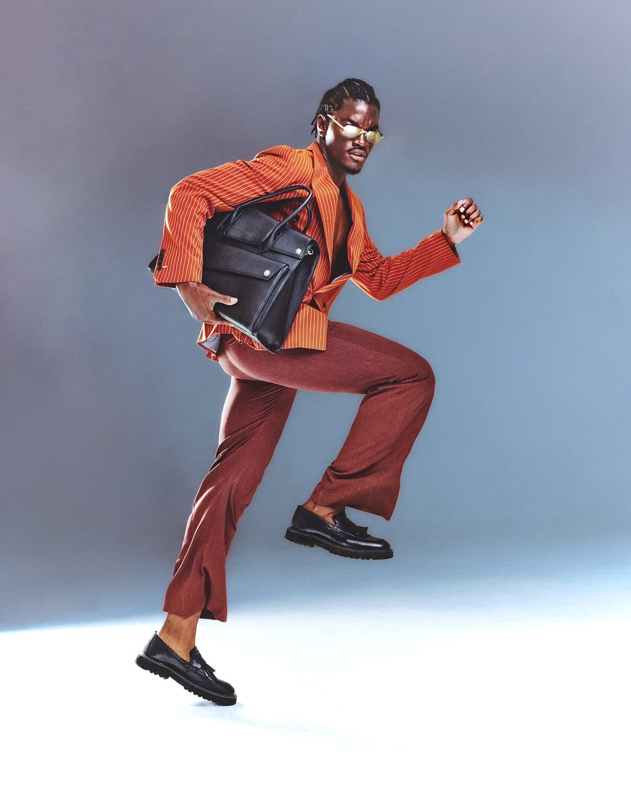 Ibo Bodi in motion, wearing an orange suit with a bag